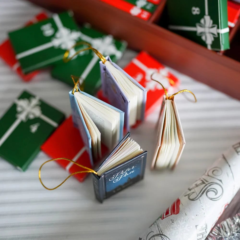 Miniature books displayed with Christmas gift boxes